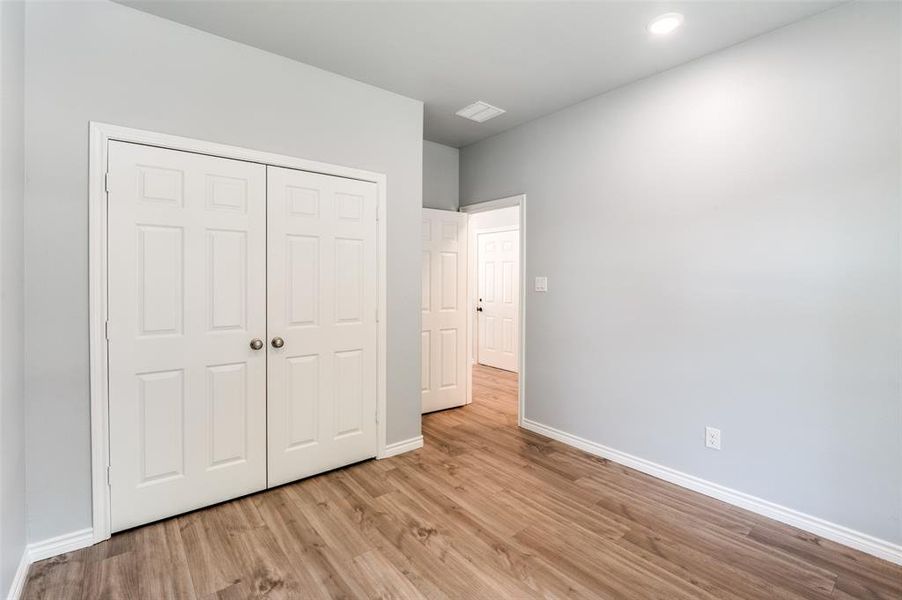 Unfurnished bedroom featuring light wood-type flooring and a closet