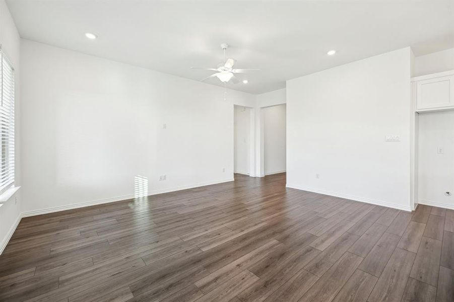 Unfurnished room with dark wood-type flooring and ceiling fan