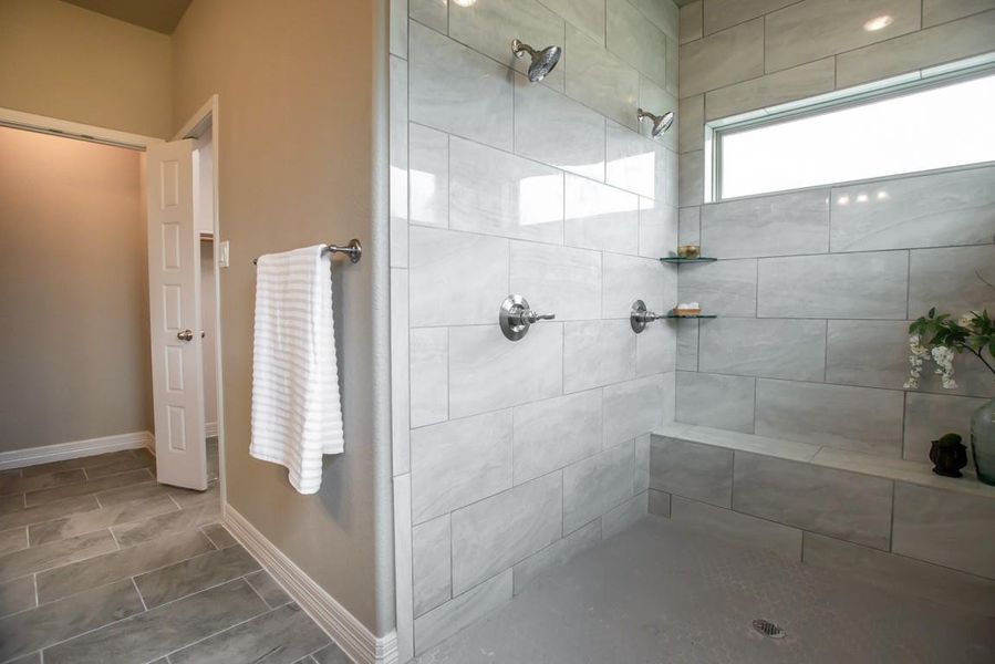 Bathroom featuring baseboards and a tile shower