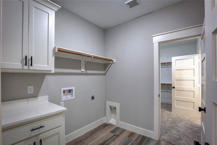 Laundry room with cabinets, carpet, electric dryer hookup, and hookup for a washing machine Laundry room with cabinets, carpet, electric dryer hookup, and hookup for a washing machine