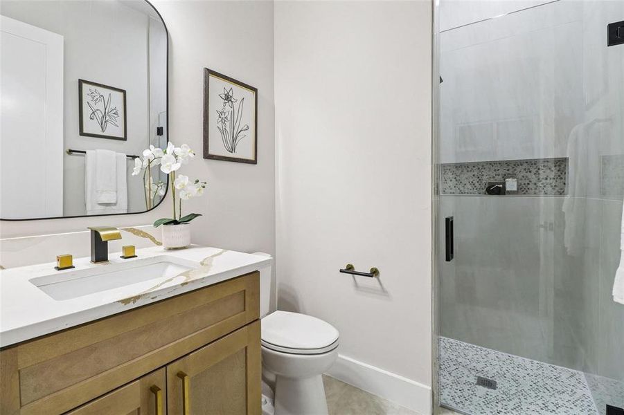 This bathroom features a contemporary vanity with a white countertop and gold-toned fixtures