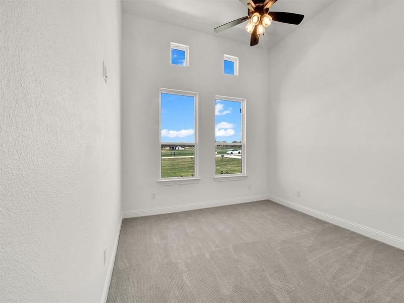 Carpeted spare room featuring baseboards and a ceiling fan Carpeted spare room featuring baseboards and a ceiling fan