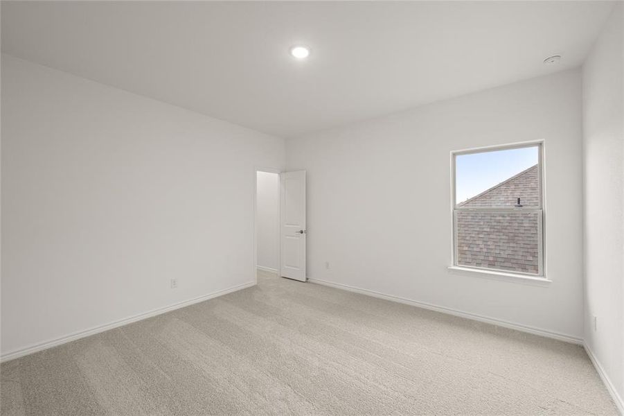 Empty room featuring light carpet, baseboards, a smoke detector, and recessed lighting