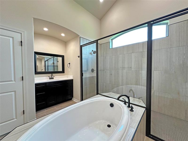 Bathroom with a bath, a shower stall, vanity, recessed lighting, and lofted ceiling