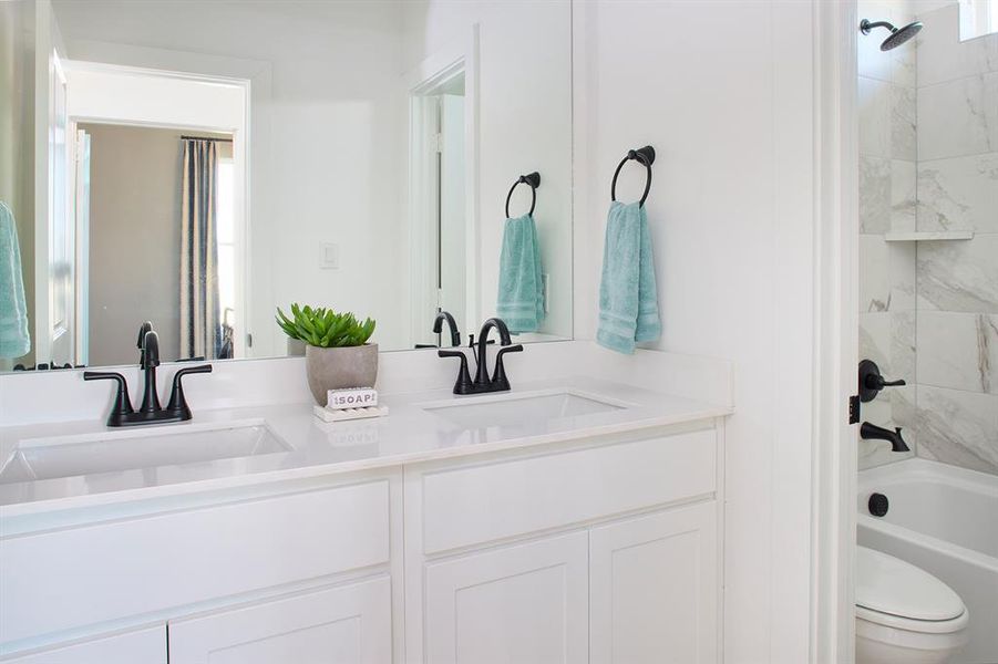 Bathroom featuring bathing tub / shower combination and double vanity