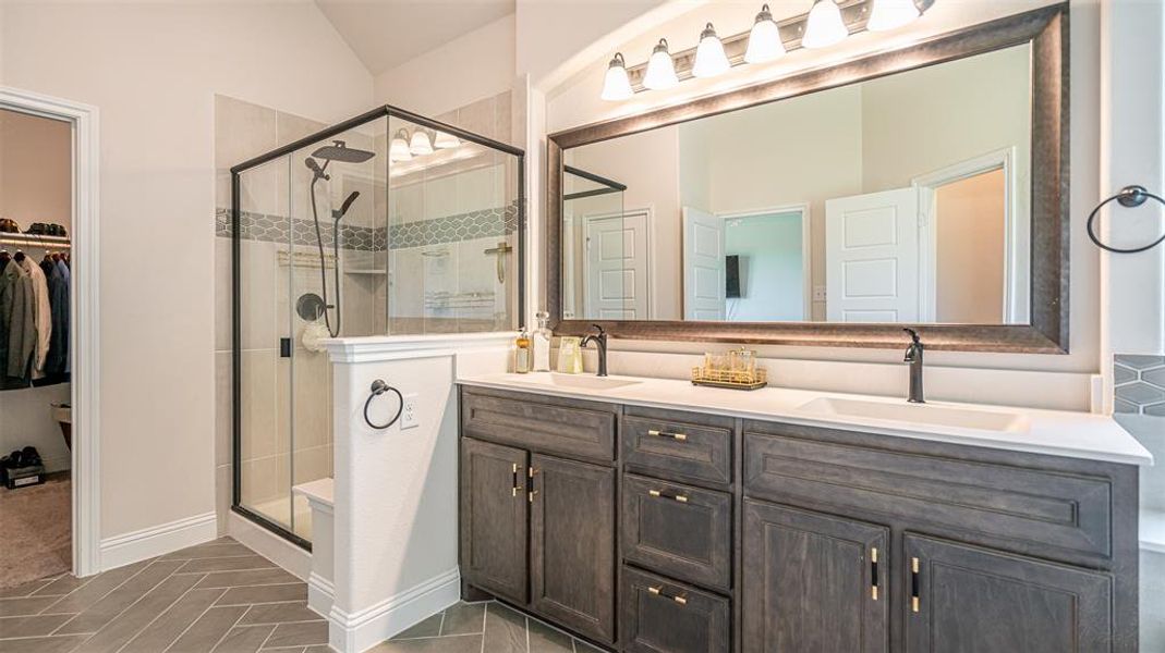 Double vanity featuring dark wood-finish cabinetry and white countertops