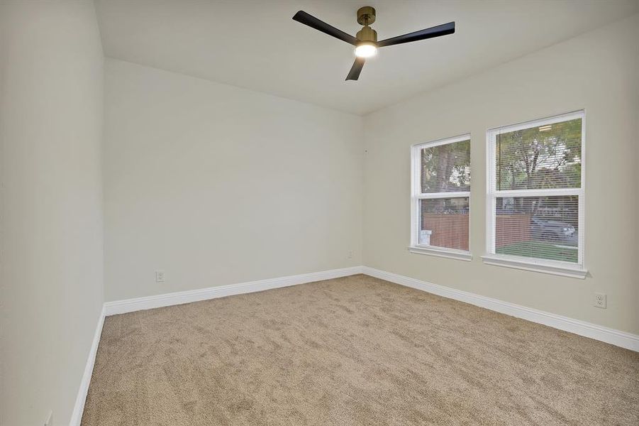 Carpeted spare room with ceiling fan