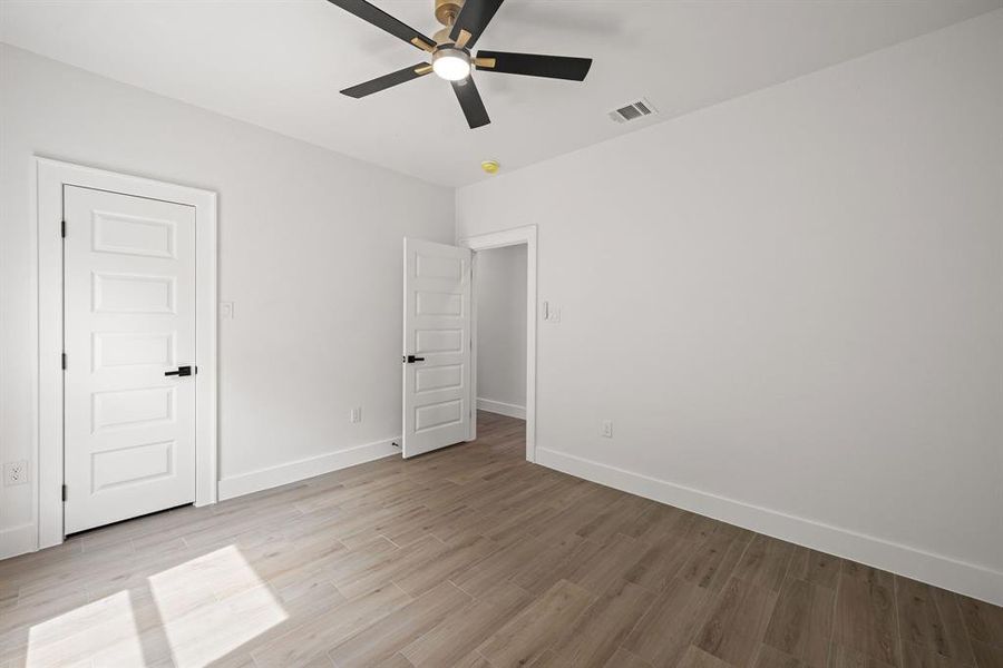 Light wood-finish flooring complements white walls with matching baseboards