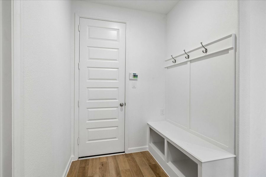 The mud room keeps everyday life organized with a built-in bench, open cubbies, and hooks for bags, shoes, and grab-and-go essentials.