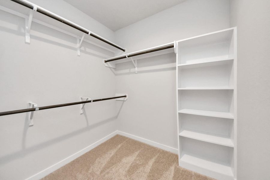 Walk-in closet that epitomizes luxury and practicality. This generously sized space features built-in shelving, offering abundant room for impeccable organization. High ceilings and recessed lighting create a bright and welcoming ambiance. Sample photo of completed home with similar floor plan. Actual colors and selections may vary. Walk-in closet that epitomizes luxury and practicality. This generously sized space features built-in shelving, offering abundant room for impeccable organization. High ceilings and recessed lighting create a bright and welcoming ambiance. Sample photo of completed home with similar floor plan. Actual colors and selections may vary.