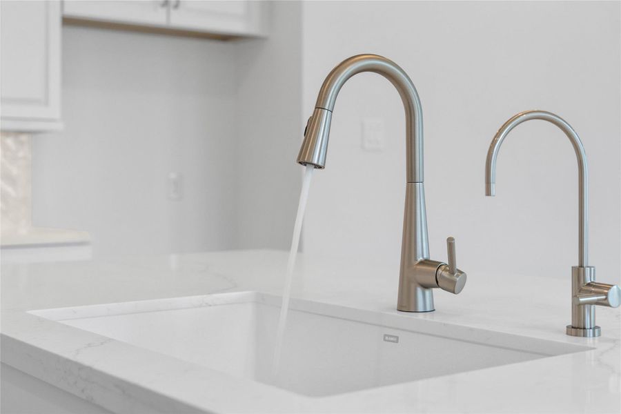 Moen Sleek - Stainless Steel pull-down faucet offers versatility and contemporary design, complemented by a convenient separate filtered water dispenser faucet.