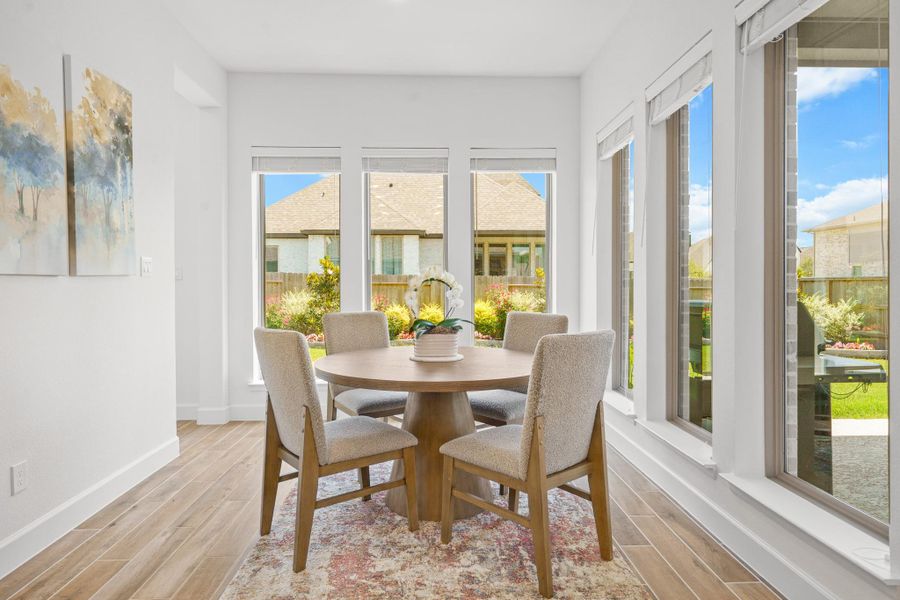Bright dining area with large windows offering a view of the covered patio and backyard.