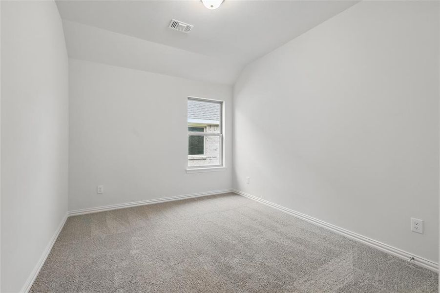 Spare room with lofted ceiling and light colored carpet