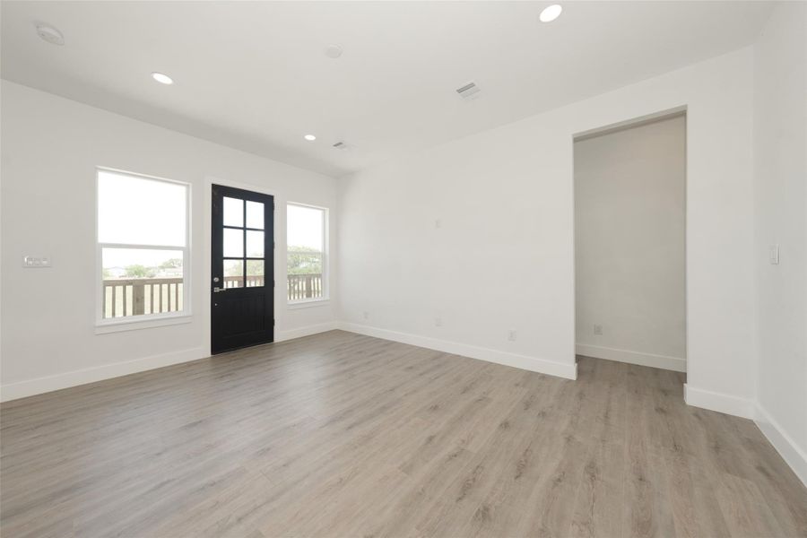 Modern kitchen featuring a sleek marble island, stainless steel appliances, and white cabinetry. It has an open layout with ample natural light from large windows and stylish pendant lighting. The gold sink and faucet are excellent touches.