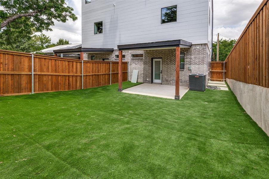 Back of house featuring a yard, a patio, and cooling unit