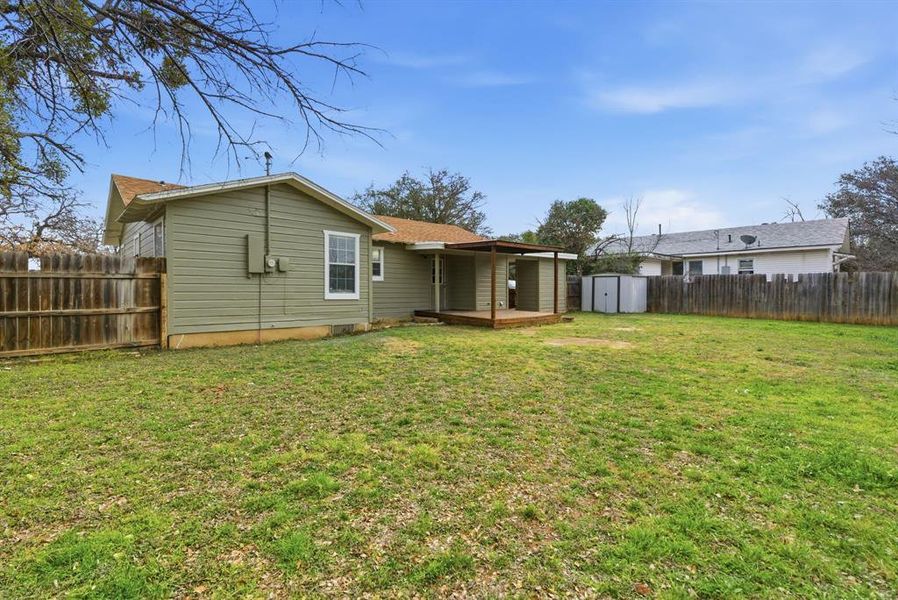 Back of house featuring a storage shed, a fenced backyard, and a wooden deck Back of house featuring a storage shed, a fenced backyard, and a wooden deck