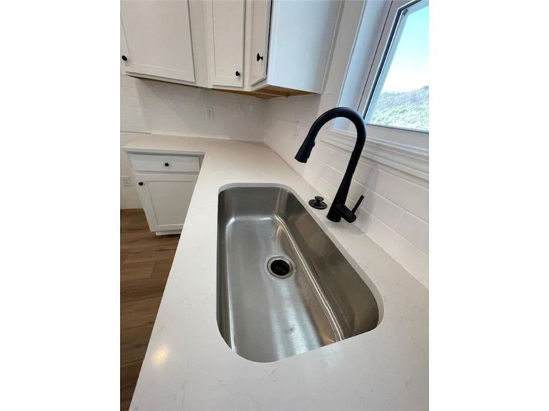 This bright kitchen features sleek countertops and