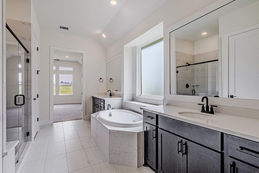 Modern fixtures, generous counter space, and thoughtful finishes complete the elegant primary bathroom Modern fixtures, generous counter space, and thoughtful finishes complete the elegant primary bathroom