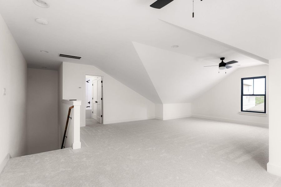 An airy loft with sloped ceilings and ample natural light offers versatile living space.
