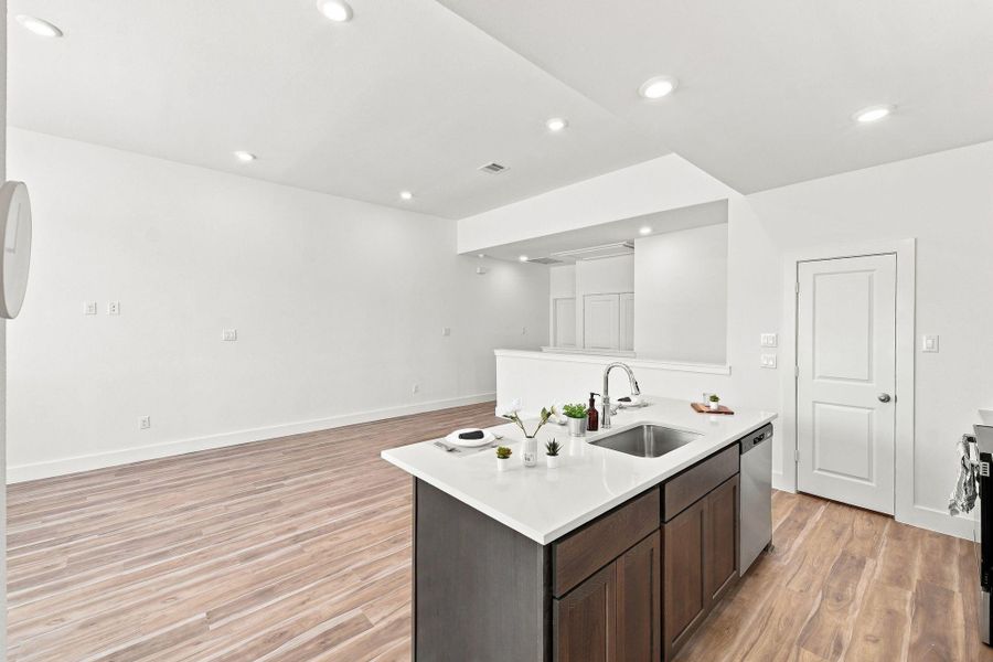 Spacious kitchen island with quartz countertop, undermount sink, dishwasher, and seating space for casual dining. Spacious kitchen island with quartz countertop, undermount sink, dishwasher, and seating space for casual dining.