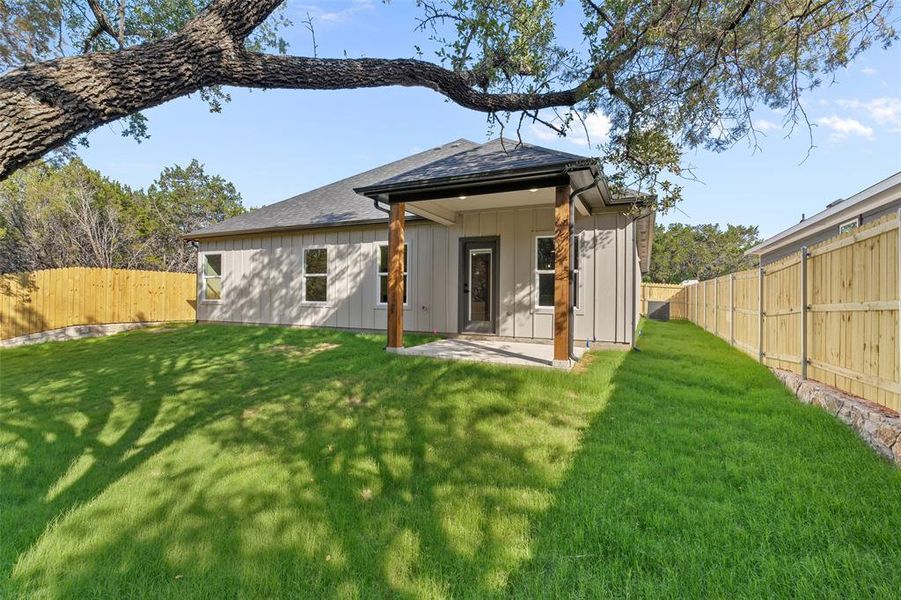 Rear view of house with a yard and a patio