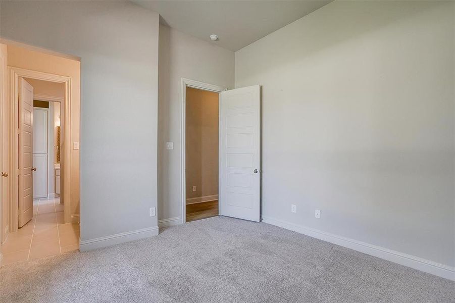 Unfurnished bedroom with light colored carpet