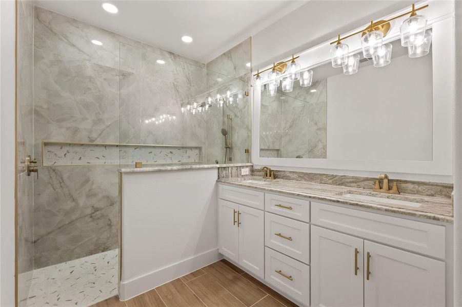 Full bathroom featuring a marble finish shower, double vanity, wood tiled floors, and recessed lighting