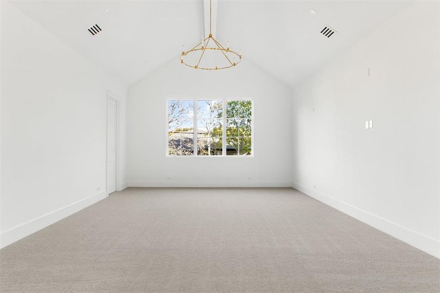 Carpeted spare room featuring baseboards and a chandelier Carpeted spare room featuring baseboards and a chandelier