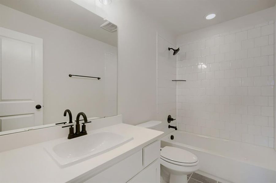 Bathroom featuring a vanity with a rectangular undermount sink, dark bronze faucet, and a large mirror