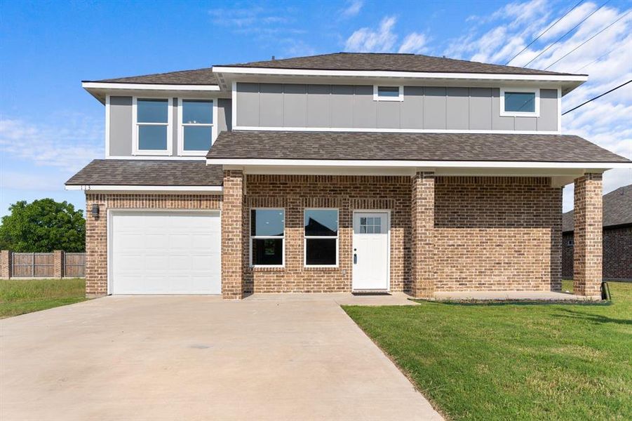View of front facade featuring concrete driveway, a garage, brick siding, roof with shingles, and board and batten siding View of front facade featuring concrete driveway, a garage, brick siding, roof with shingles, and board and batten siding