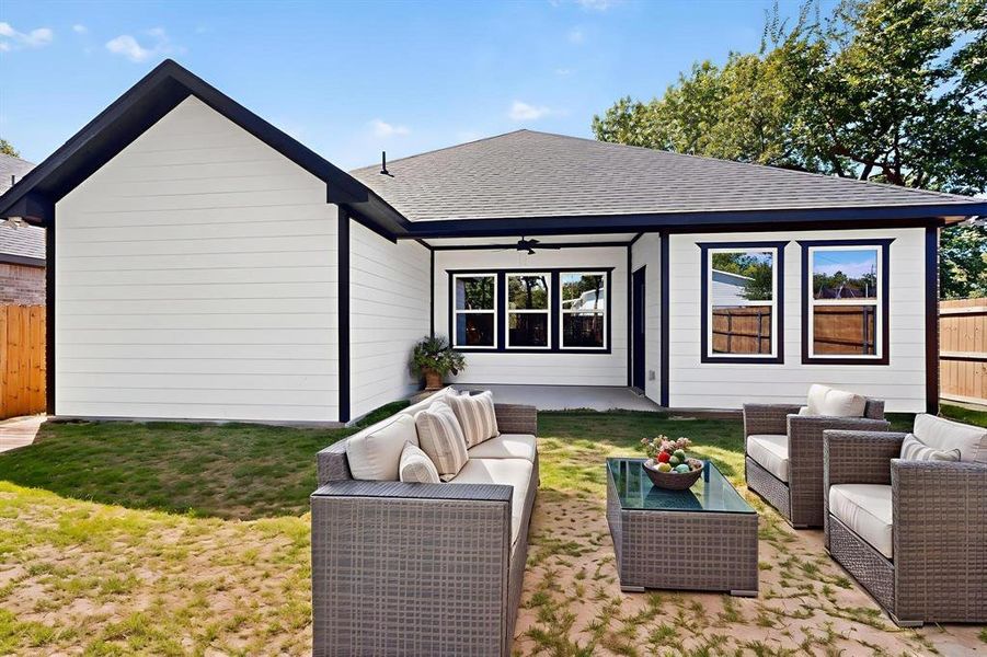 Back of property with a ceiling fan, outdoor lounge area, roof with shingles, and a patio area