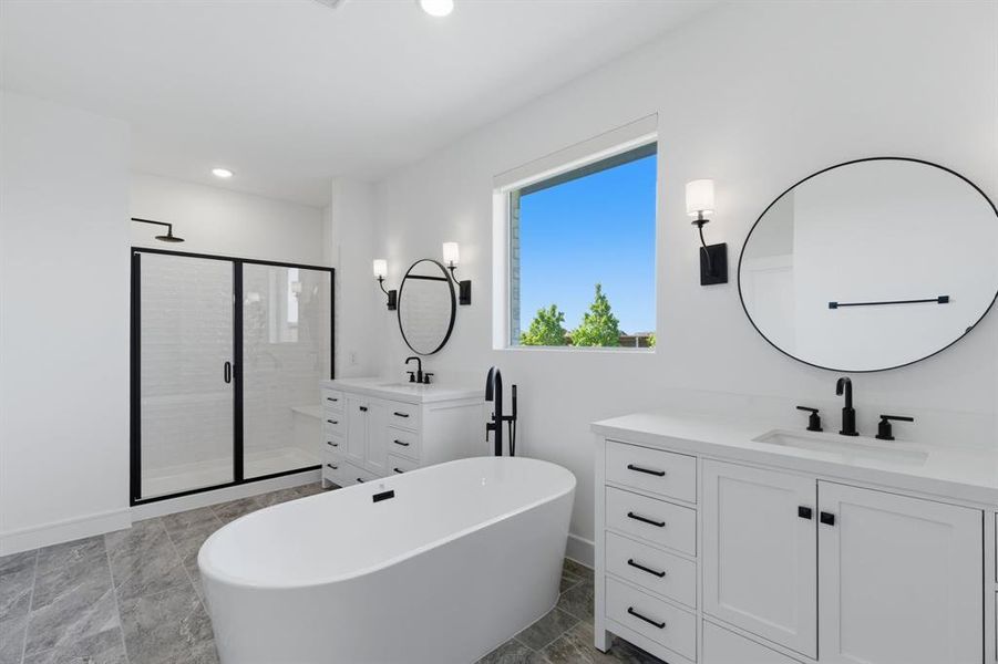 Primary
bathroom with vanity, a stall shower, a freestanding bath, dark marble finish floors, and recessed lighting Primary
bathroom with vanity, a stall shower, a freestanding bath, dark marble finish floors, and recessed lighting
