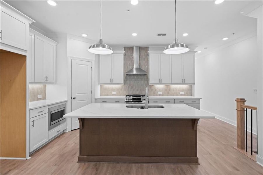 This beautifully appointed kitchen showcases a timeless neutral design, featuring soft vanilla-painted cabinets that create a light and airy atmosphere.
