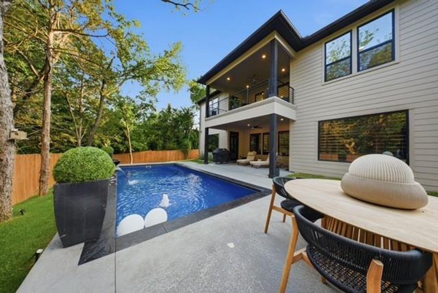 Contemporary two-story exterior with an expansive concrete patio and integrated swimming pool