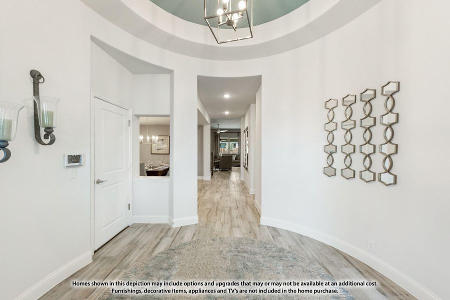 Foyer with round tray ceiling, chandelier, wood-look floors, and hallway leading to living areas Foyer with round tray ceiling, chandelier, wood-look floors, and hallway leading to living areas