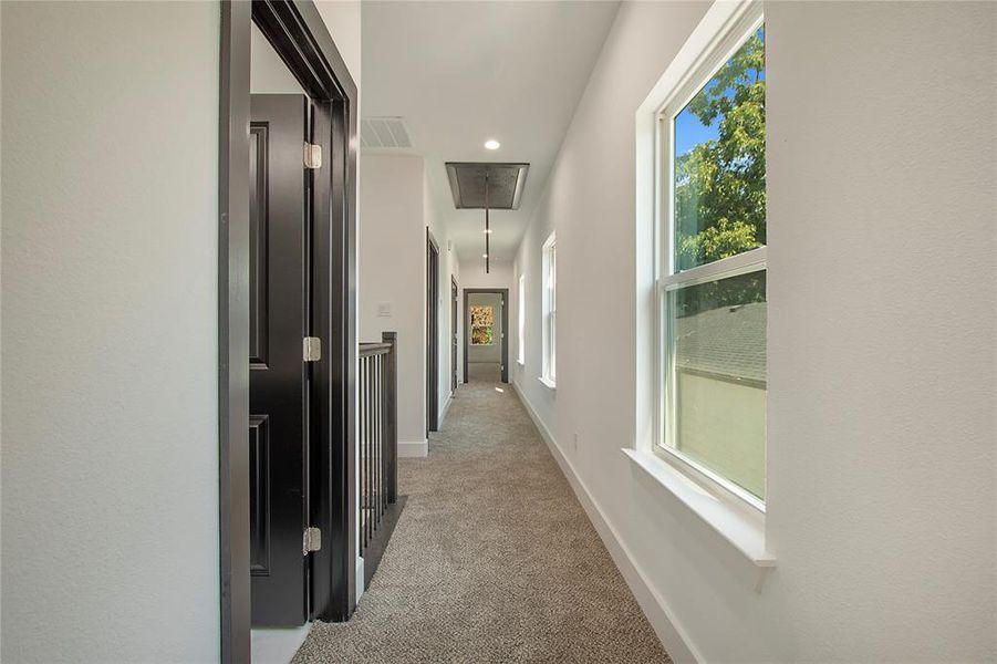 Corridor featuring light colored carpet