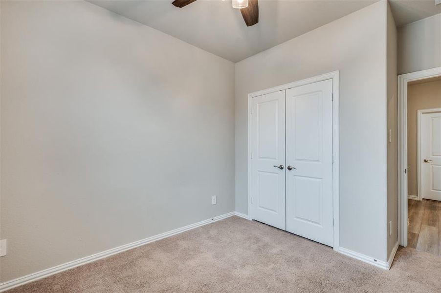 Unfurnished bedroom featuring carpet, a closet, and ceiling fan
