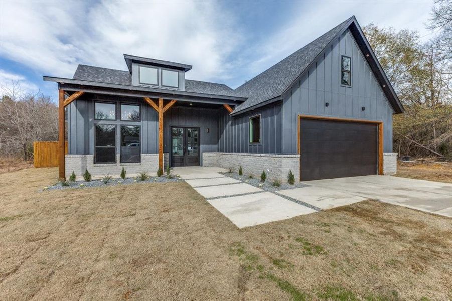 View of front of house with french doors, a front lawn, and a garage