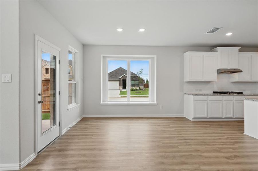 Unfurnished dining area featuring light wood-style floors, baseboards, and recessed lighting Unfurnished dining area featuring light wood-style floors, baseboards, and recessed lighting