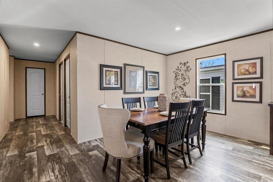 Dining area with dark wood-type flooring and recessed lighting