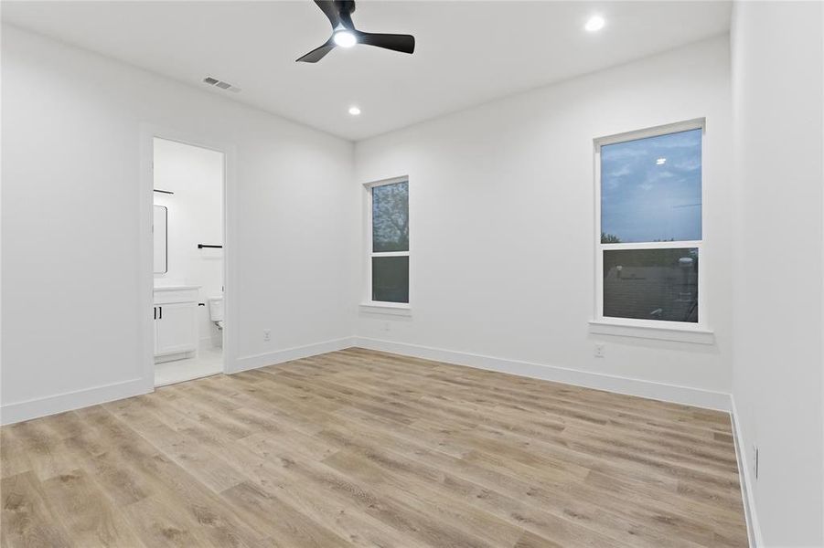 Unfurnished bedroom featuring ceiling fan, light wood-style floors, recessed lighting, and ensuite bathroom