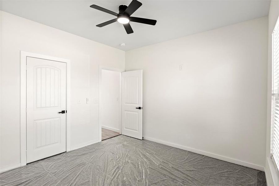 Unfurnished bedroom with a ceiling fan and carpet