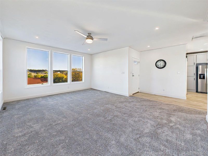 Unstaged version of the main living area, highlighting the fresh paint, new carpet, and seamless flow into the kitchen. Unstaged version of the main living area, highlighting the fresh paint, new carpet, and seamless flow into the kitchen.