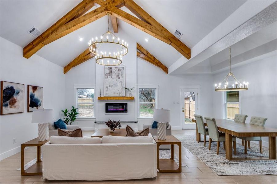 Living room featuring wood-type flooring, beamed ceiling, high vaulted ceiling, and a chandelier