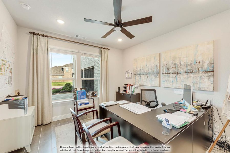 Home office with large dark wood desk, ceiling fan, tile floors, and a window with natural light