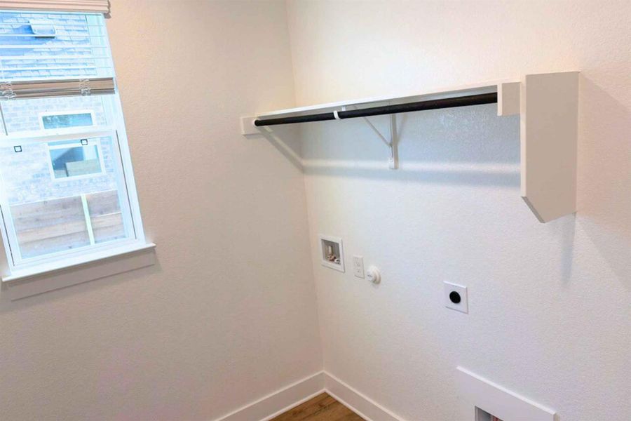 Laundry area featuring hookup for a washing machine, gas dryer hookup, wood finished floors, and electric dryer hookup Laundry area featuring hookup for a washing machine, gas dryer hookup, wood finished floors, and electric dryer hookup