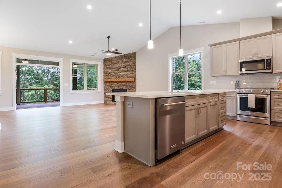 Spacious living area flows to covered Trex decking with peaceful wooded views