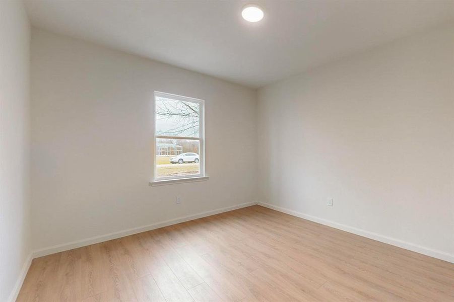 Unfurnished room featuring light wood-style flooring and baseboards