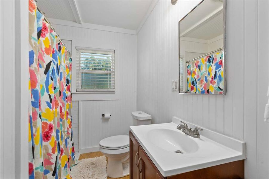 Bathroom with vanity, crown molding, wood finished floors, and a shower with shower curtain Bathroom with vanity, crown molding, wood finished floors, and a shower with shower curtain