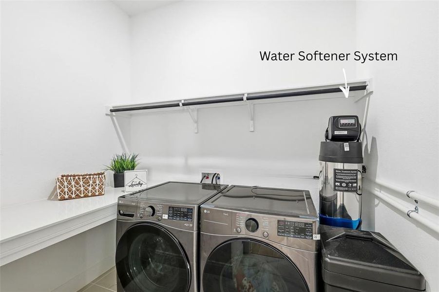 Spacious laundry with a folding table and water softener equipment. Spacious laundry with a folding table and water softener equipment.